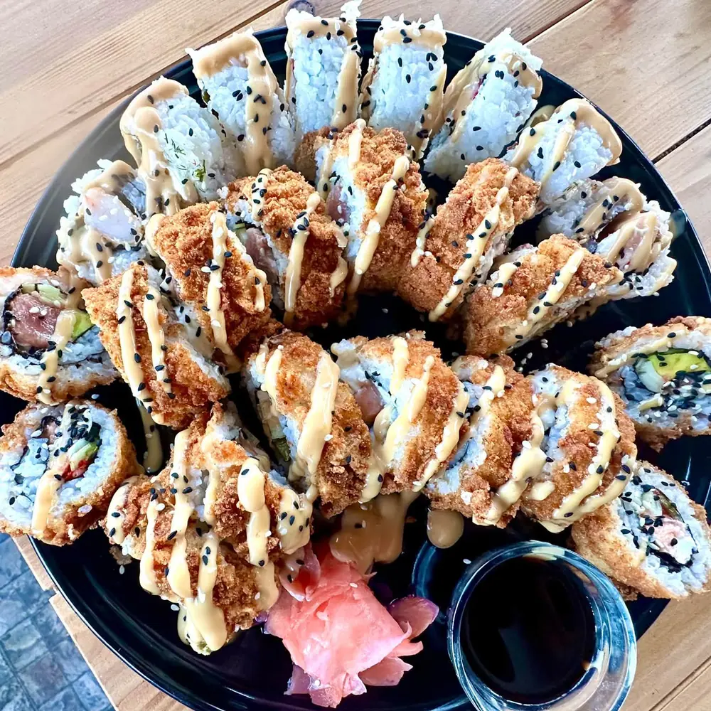 A dark platter of tempura and uramaki rolls